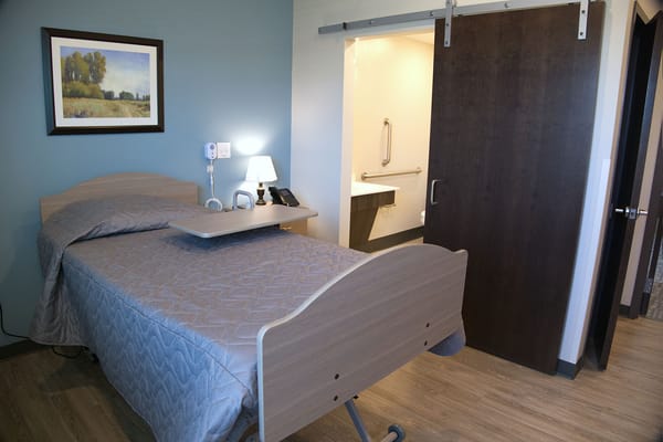 Private resident room with a hospital bed and bathroom