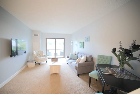 Bright living room with comfortable seating and a TV.