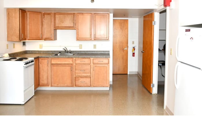 View of a kitchen with wooden cabinets and appliances