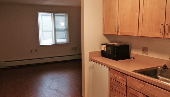 Kitchen with microwave and entryway to living area in a senior living apartment