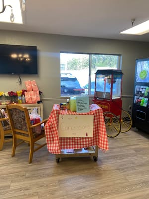 Concessions stand with drinks and snacks, featuring a popcorn machine.
