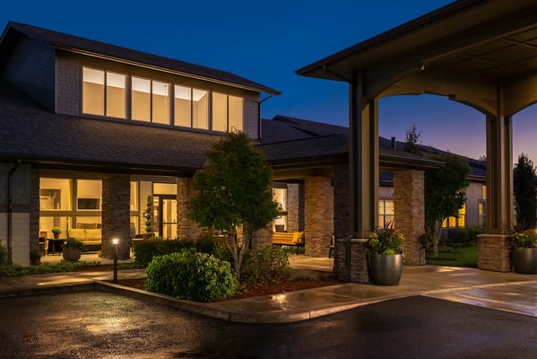 Evening view of the facility entrance with landscaping
