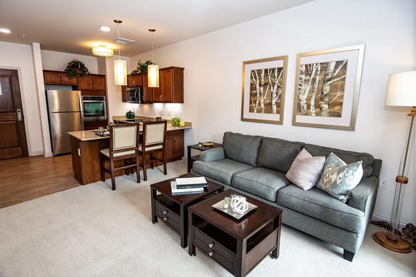 Living room with a sofa, coffee tables, and kitchen area