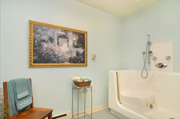 A serene bathroom with a large bathtub and artwork
