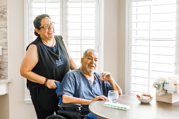 A staff member assisting a resident at a dining table