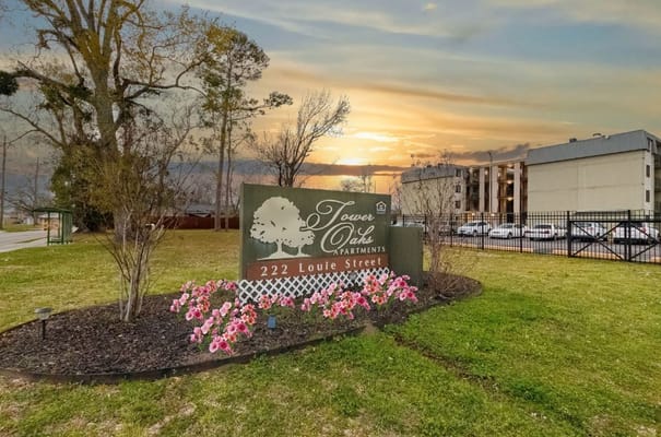 Exterior view of Tower Oaks Apartments with flowers.