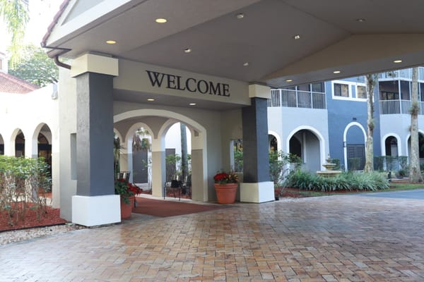 Entrance of a senior living facility with a welcoming sign