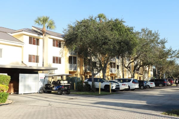 Building exterior view with parking and golf cart