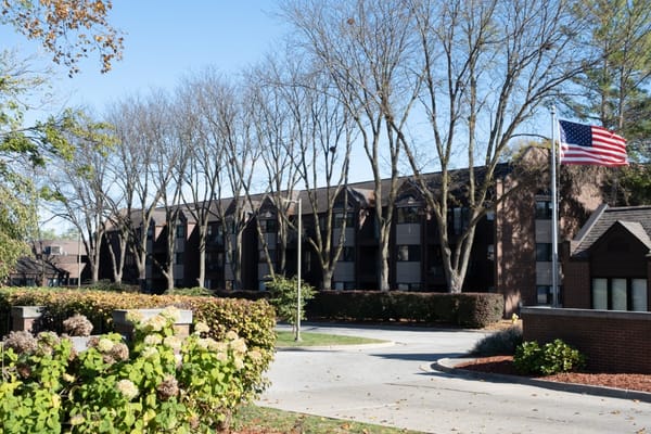 Exterior view of Elite Lodge of Ashworth with trees and flag