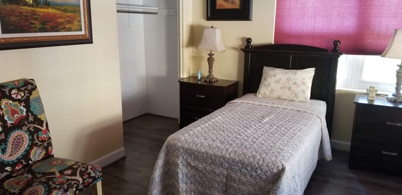 Cozy resident room with bed and decorative chair