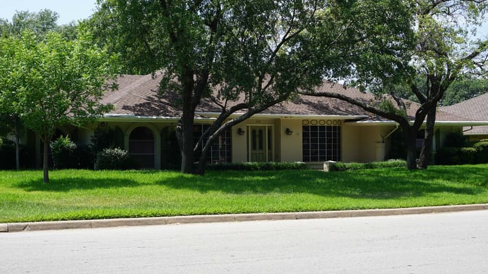 Exterior view of an assisted living facility surrounded by greenery