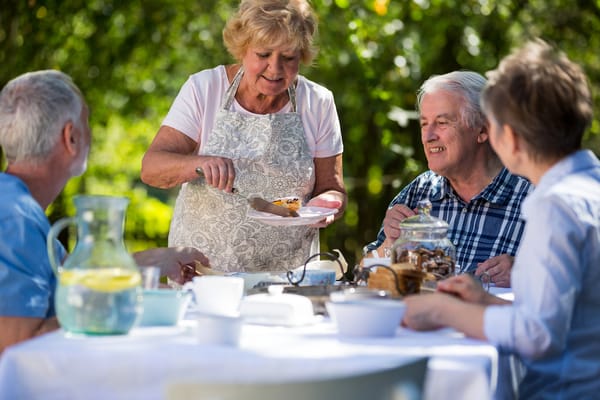 Residents enjoying dessert outdoors at a communal table