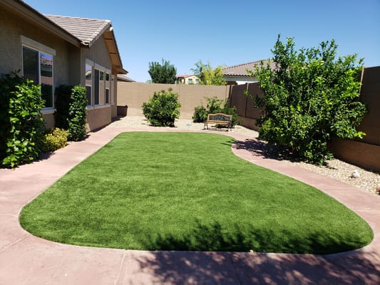 Well-maintained outdoor space with artificial grass and plants