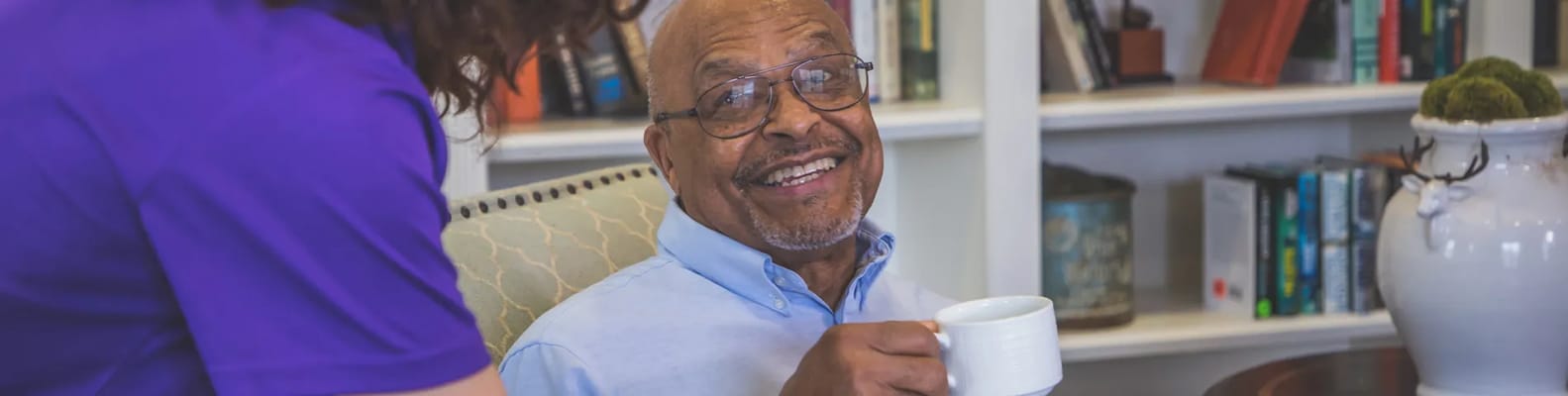 Resident enjoying a warm drink in a cozy common area