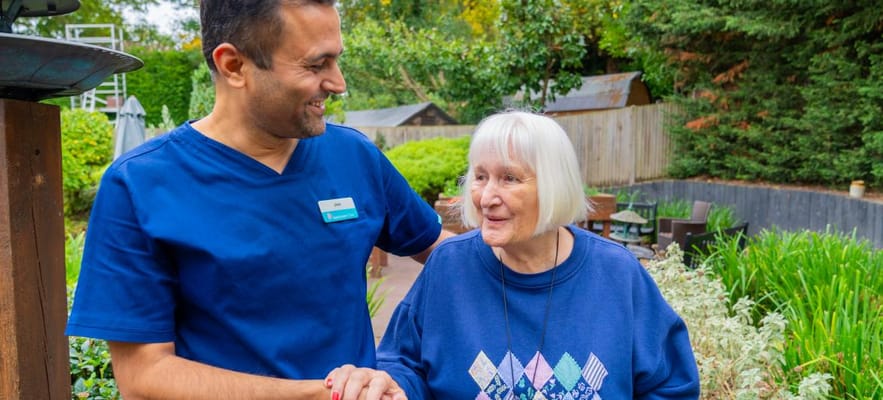 Staff member interacting with a resident in a garden