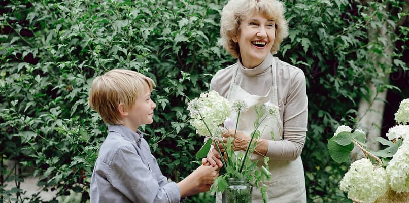 Resident and child preparing flower arrangements outdoors