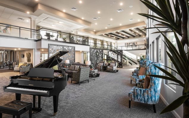 Bright and spacious common area with piano and seating