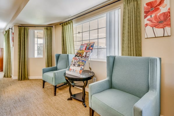 Cozy common area with blue chairs and magazines