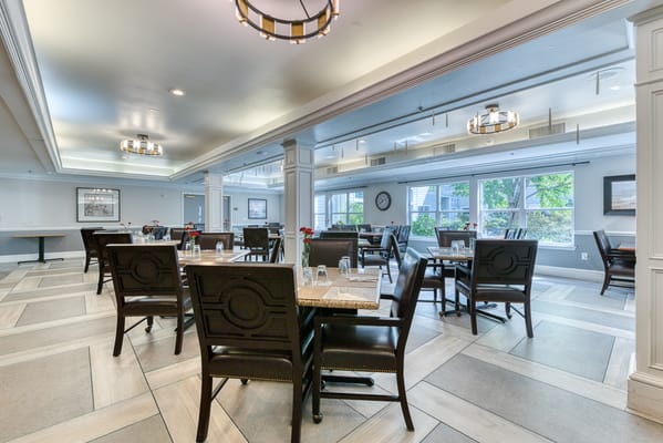 Dining area with tables and chairs set for residents