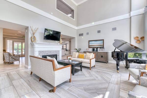 Bright, welcoming common area with seating and piano