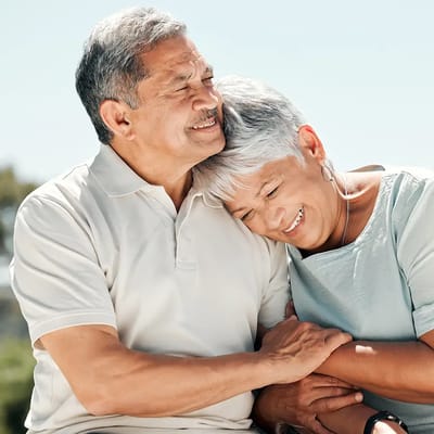 Elderly couple smiling together outdoors
