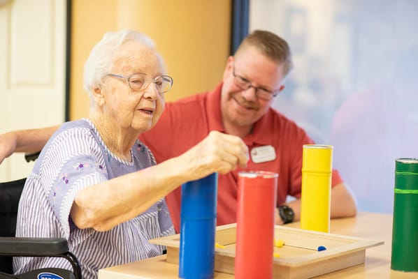 Resident engaging in an activity with staff assistance