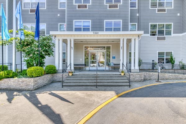 Front entrance of Kenmore Senior Living with steps and signage.