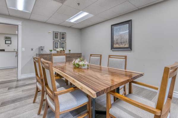 A well-lit common area with a wooden dining table