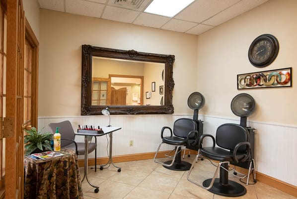 Hair salon area with styling chairs and mirror