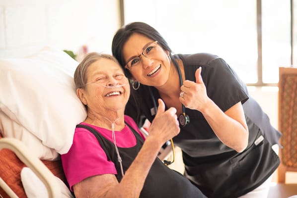 Staff member and resident smiling together in a care facility