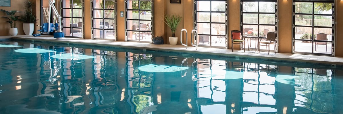 Indoor pool area with large windows and seating