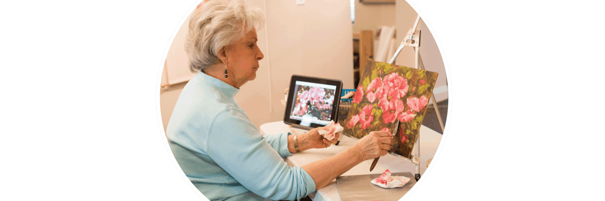 Resident painting flowers in an activity room