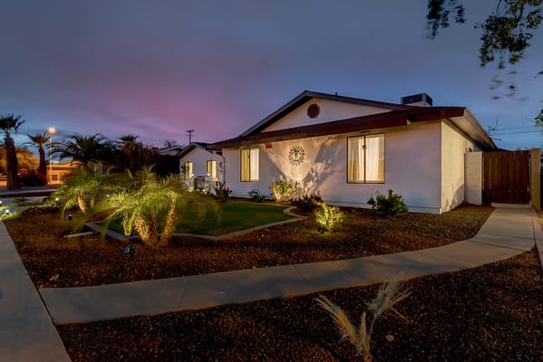 Exterior view of a care facility at dusk with landscaping