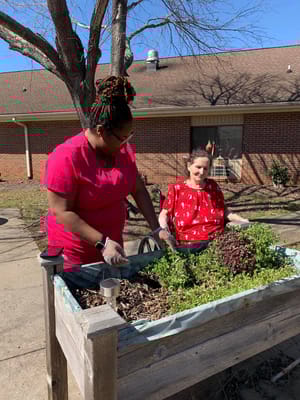 Staff and resident gardening in an outdoor space