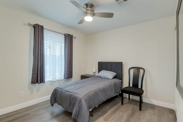Private room with a bed and chair in a senior living facility
