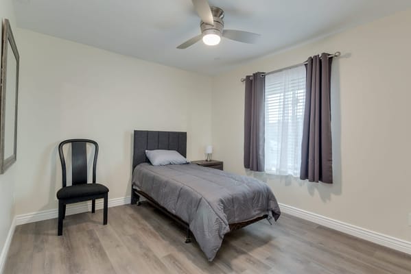 Simple bedroom setup with a bed and chair