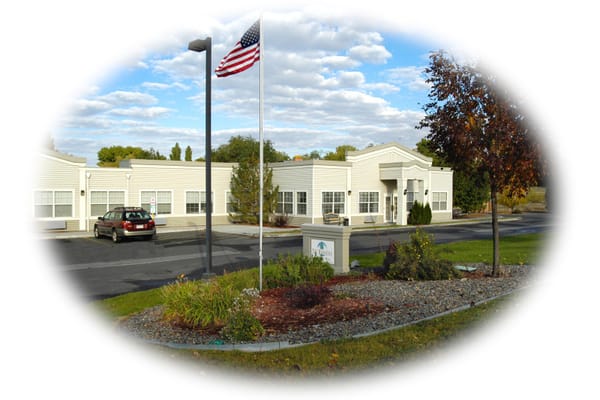 Exterior view of the facility with landscaping and flag
