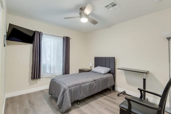 A private resident room with a bed and desk