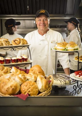 A chef presenting a variety of baked goods
