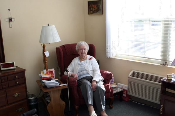 An elderly woman seated in a cozy room