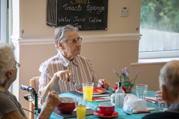 Resident enjoying a meal in the dining room