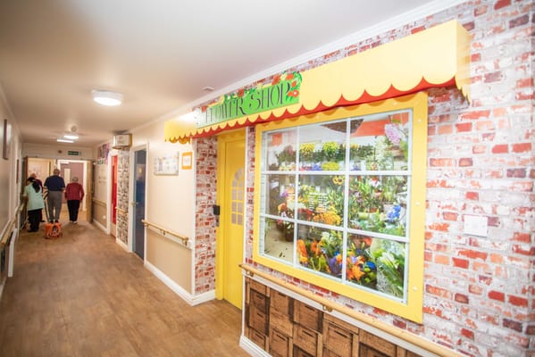 Corridor with a flower shop area and residents walking