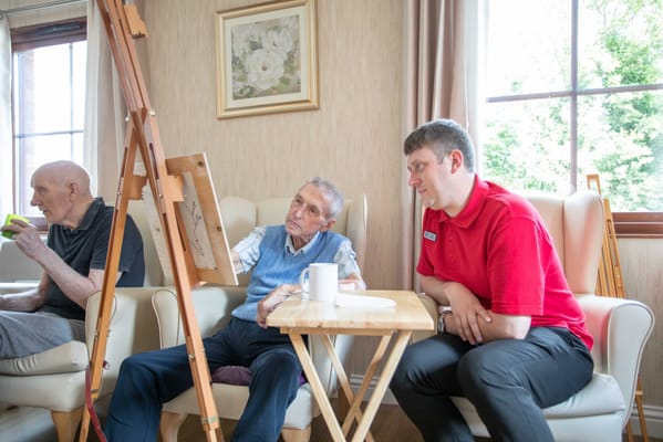 Residents engaging in an art activity with staff guidance