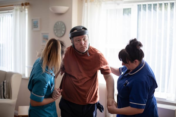 Care staff assisting a resident in a bright room