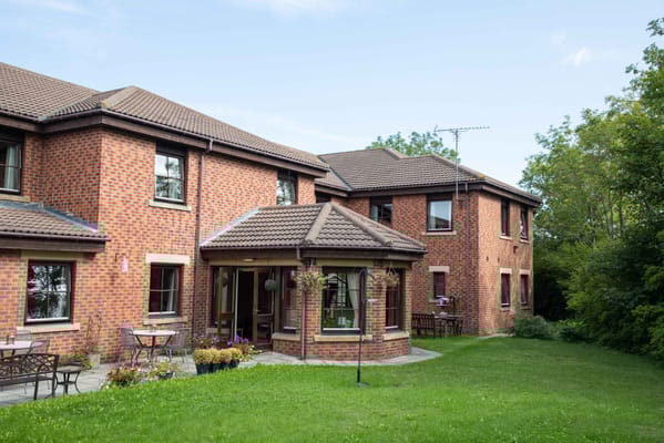 Exterior view of a nursing home building with garden