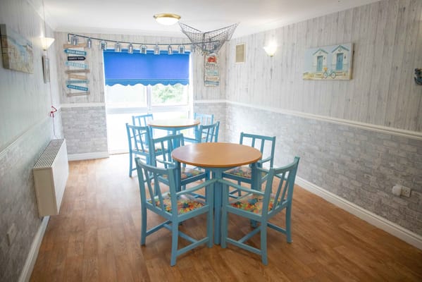 Bright common area with blue chairs and tables