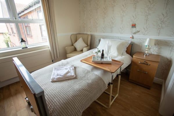 Cozy resident room with a bed and dining tray