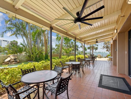 Outdoor seating area with tables and fans