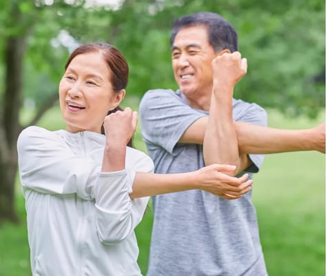 Seniors stretching together in a green outdoor space