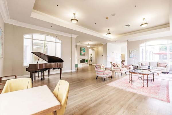 Bright common area with a grand piano and seating